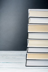 Open books on wooden table, black board background. Back to school. Education business concept.