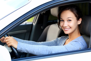 Fototapeta na wymiar Beautiful woman driver smiling to you from her car