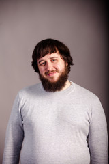 Obraz premium confident, lucky man with beard in front of grey background