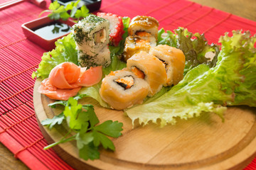 Beautifully decorated sushi on a plate and chopsticks are near it