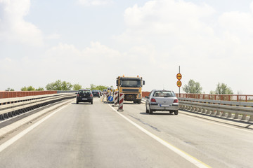 Fototapeta na wymiar Column flow of vehicles on the road works on the bridge