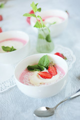 Cold creamy strawberry soup with a scoop of ice cream and mint