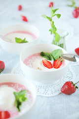 Cold creamy strawberry soup with a scoop of ice cream and mint