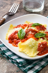 Ravioli with tomato sauce and basil on wooden table
