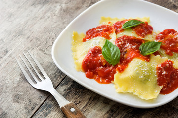 Ravioli with tomato sauce and basil on wooden table
