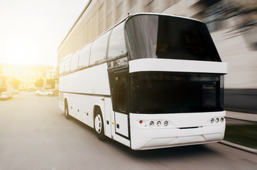 Modern tourist bus on asphalt in the evening on sunset.