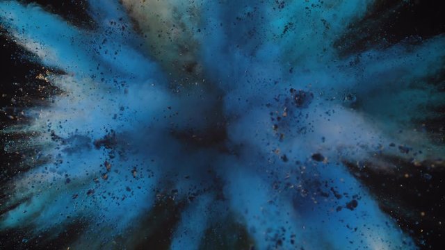 Colorful powder/particles fly after being exploded against black background. Shot with high speed camera, phantom flex 4K. Slow Motion. 
