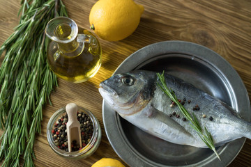 Raw fish cooking and ingredients. Dorado, lemon, herbs and spices.
