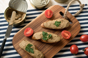 Fototapeta premium Liver pate on the bread on wooden tray.