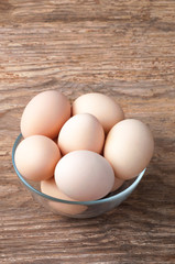 Brown Hen eggs in bowl on wooden table. Fresh farmer's egg