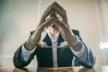 male businessman in handcuffs as a symbol of corruption