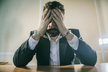 male businessman in handcuffs as a symbol of corruption