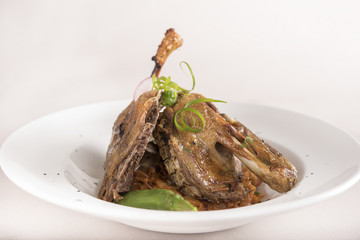 Traditional dish with baked drumstick duck and sour cabbage, decorated with herbs, placed on white plate, light background, isolated