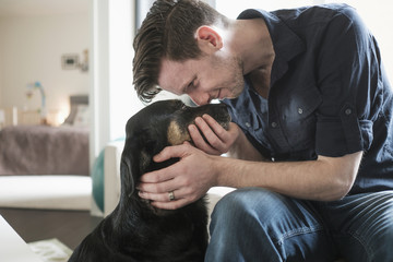Man playing with dog in living room