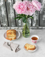 apple cake and tea. Peonies, linen and metal sppon