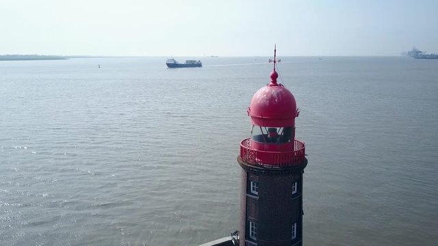 Ascending over a lighthouse with a ship in the background