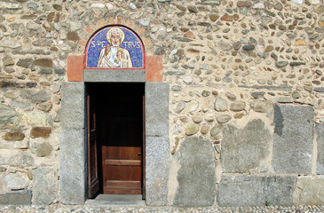 Door and mosaic lunette on the facade of a romanesque italian church