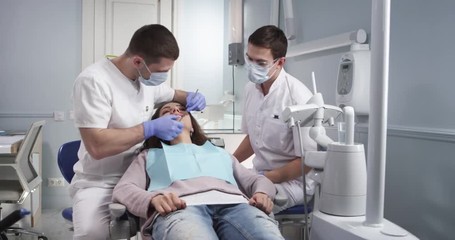 Examination of the oral cavity of a patient by a dentist in a modern dental office - Powered by Adobe