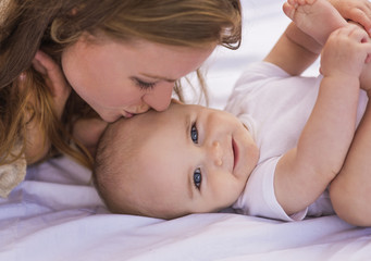 Mother kissing baby (6-11 months)