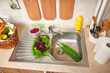vegetables and fresh greens in basket in kitchen interior, healthy food concept, top view