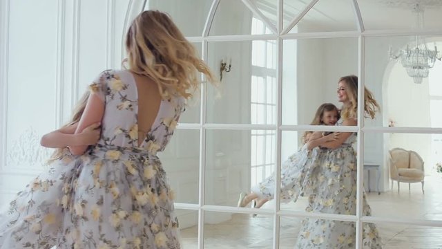 mom turns daughter's house around a large mirror and window in the white room