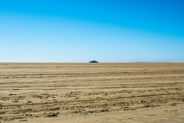 very big sand space with a blue background sky