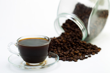 Grains of coffee and a cup of black coffee on a white background, studio light