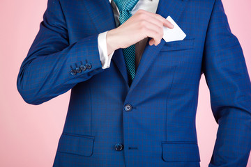 young man takes out blank business card from jacket pocket