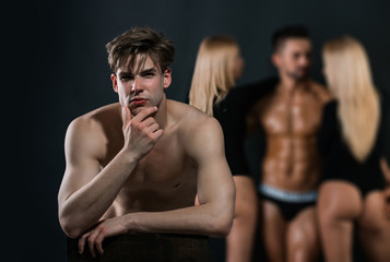thoughtful man with bare chest near guy and women