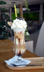 Delicious iced coffee with whipped cream on a glass cup.