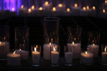 Burning candles of granulated white wax in glass candleholders