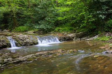 Mountain river with small waterfall