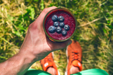 Smoothie drink a sport man in a nature. Glasses of smoothie with berry and mint. Berry, leaf and lime, raspberriesFruit Healthy food. Take a way breakfast.