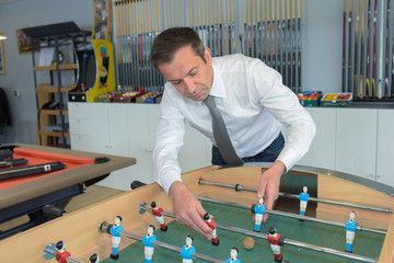 shop assistant fixing a football table