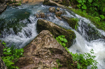 Beautiful wallpaper milk waterfall flow rapid stream. Caucasus rocky mountain river in forest. Isichenko waterfall, Guamka, Mezmay.