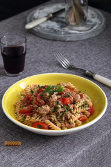 piatto di pasta italiana con pesce, tonno e pomodori