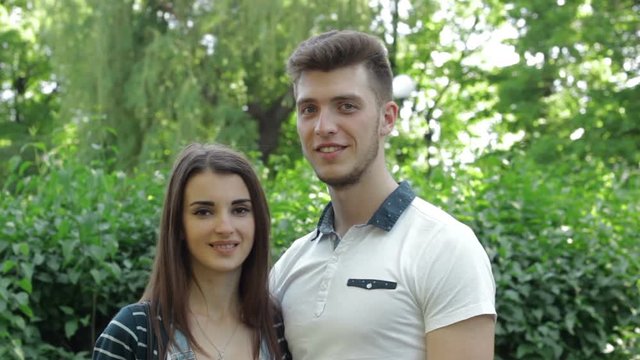 cute young couple at the park smiling on camera