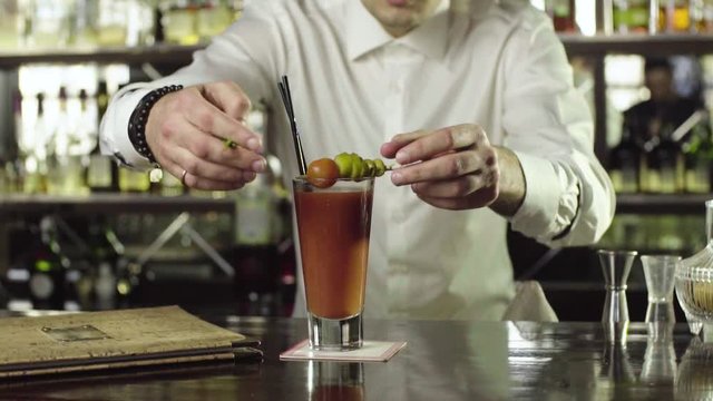 Barman decorates a cocktail with mint close-up slow motion.