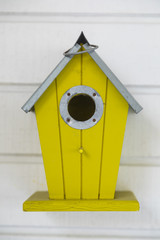 Small wooden birdhouse hanging outdoors in backyard.