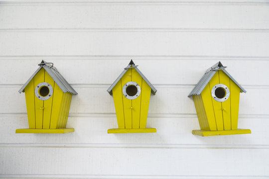 Small wooden birdhouse hanging outdoors in backyard.
