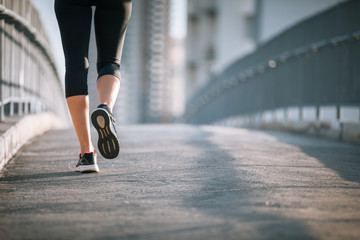closeup of female's feet running on city bridge. 