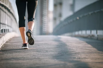 Photo sur Plexiglas Jogging closeup of female's feet running on city bridge. 