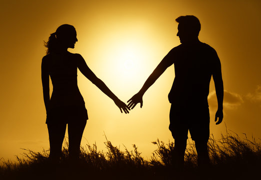 People, love and relationships. Silhouette of man and woman holding hands. 