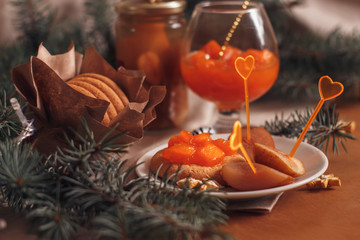 Fototapeta na wymiar plate with pumpkin jam, oatmeal cookies and fir sprigs