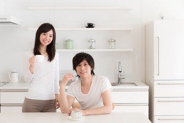 Naklejka na ściany i meble young asian couple relaxing in kitchen