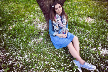 Beautiful happy young woman enjoying smell in a flowering spring garden.