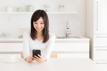 young asian woman relaxing in kitchen