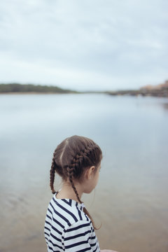 petite fille avec des tresses dans l'eau