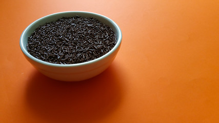 Sweet chocolate granulated in white pot on orange background