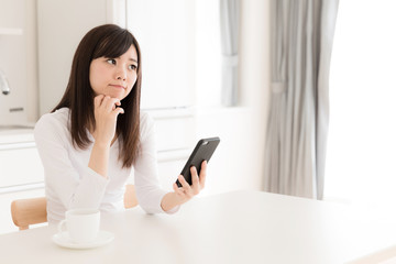 young asian woman relaxing in kitchen